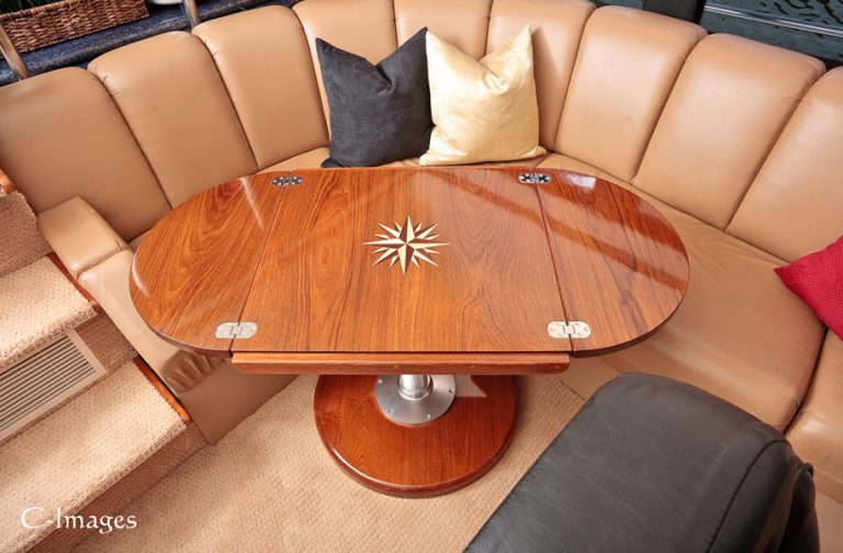 Teak boat table with inlaid design and leaves unfolded