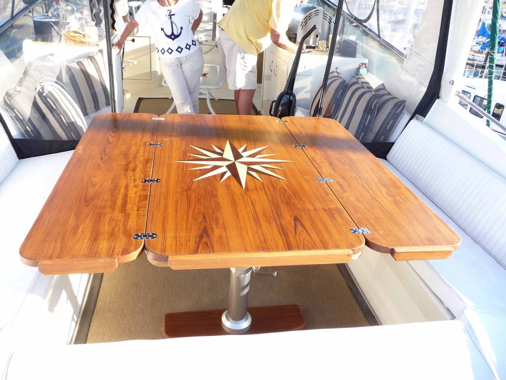 Unfolded teak yacht table with inlaid design