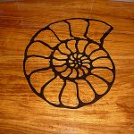 Carved teak inlay of seashell for boat cockpit table